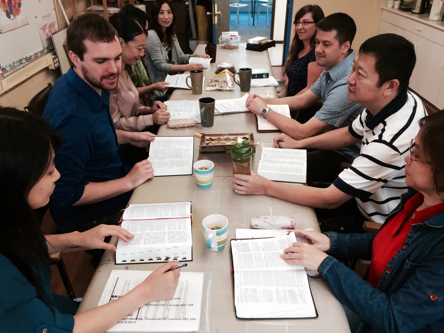 People gather around open Bibles during a shared study at a table
